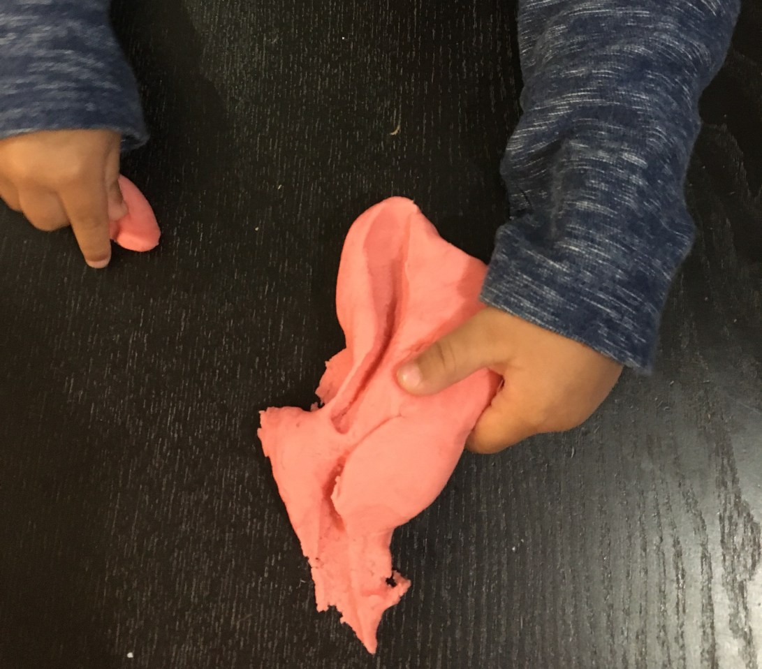 Toddler boy playing with homemade play doh