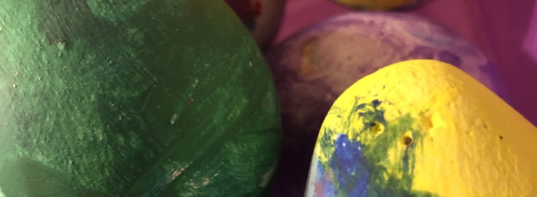 Handmade concrete eggs with a natural textured finish, displayed outdoors in a garden setting