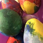 Handmade concrete eggs with a natural textured finish, displayed outdoors in a garden setting